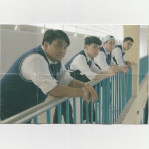 The friends are leaning on a rail, looking at the distance.