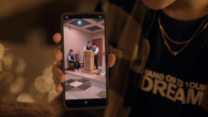 The Protagonist showing his date a video of his friends.